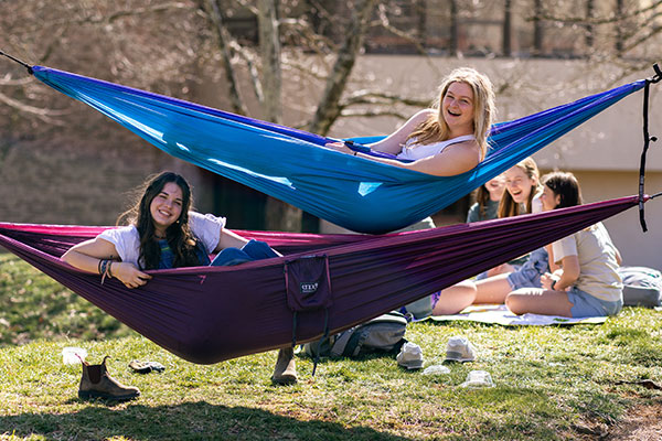 female students in hammocks on campus