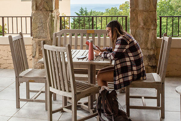 female student studying at a table outside