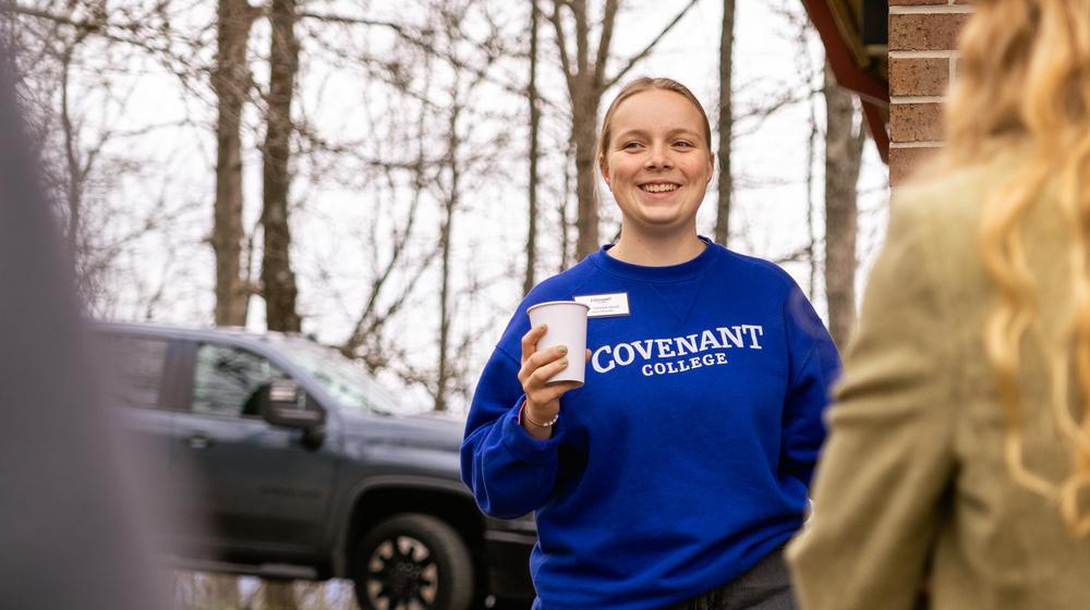 Student wearing 威尼斯人平台 sweatshirt holding a cup during campus tour.