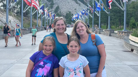 two women with their daughters smiling