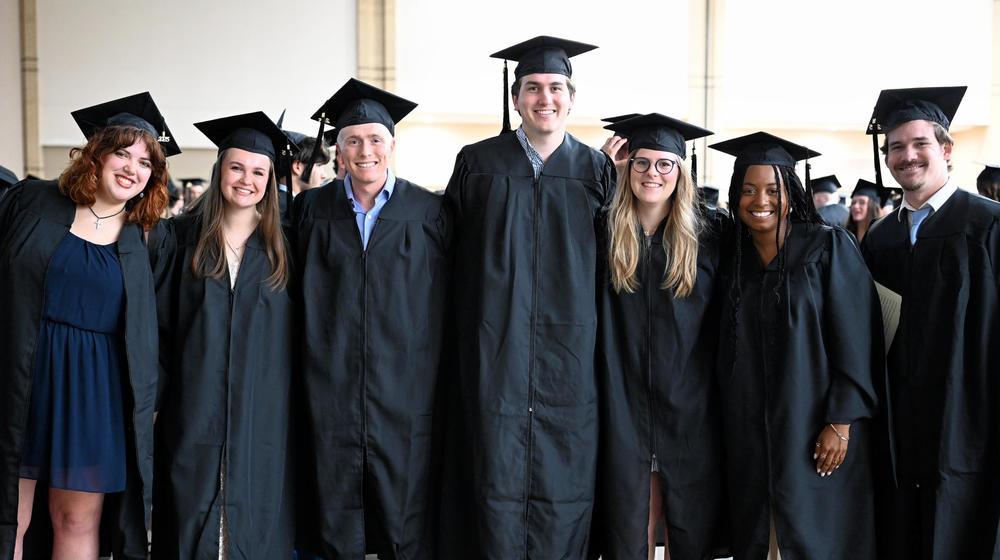 group of graduates smiling and posed for the camera