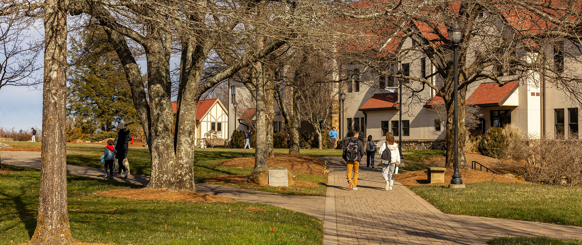 students walking outside on campus sidewalk