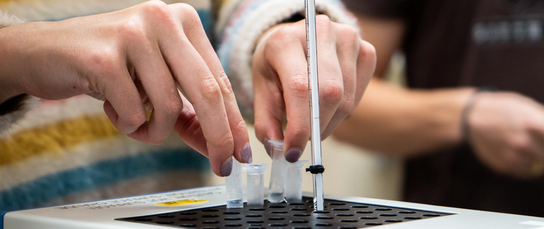 fingers picking up vial