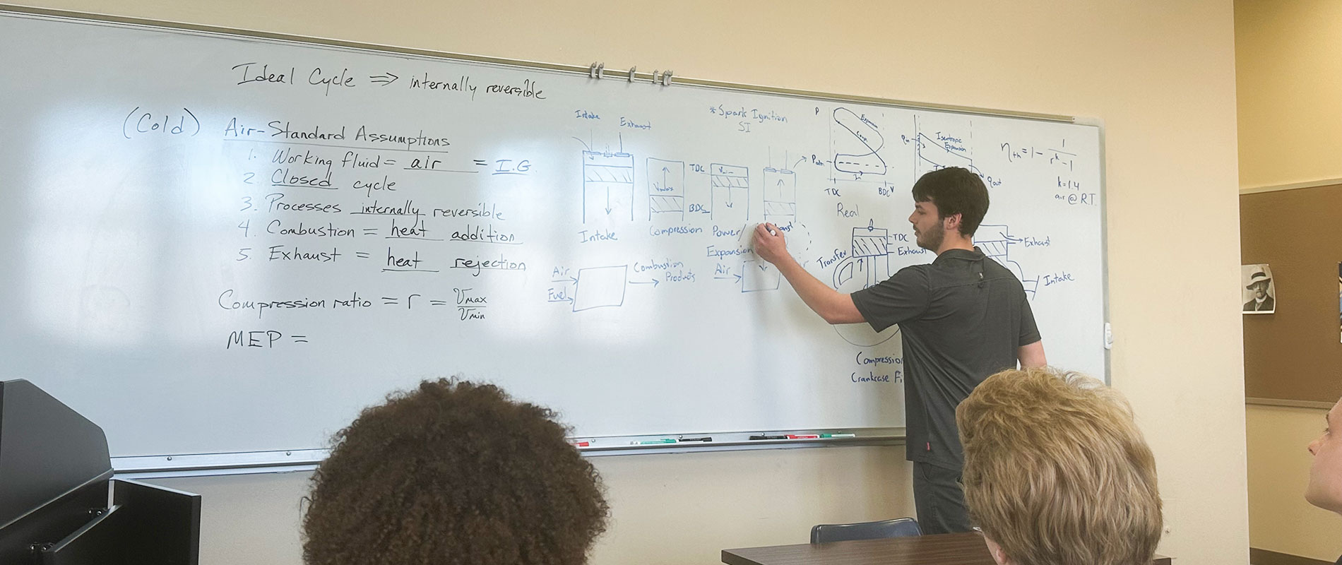 student working equations on white board
