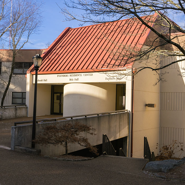 Exterior view of 创始人 Residence Center with a red metal roof and a raised walkway leading to the entrance.